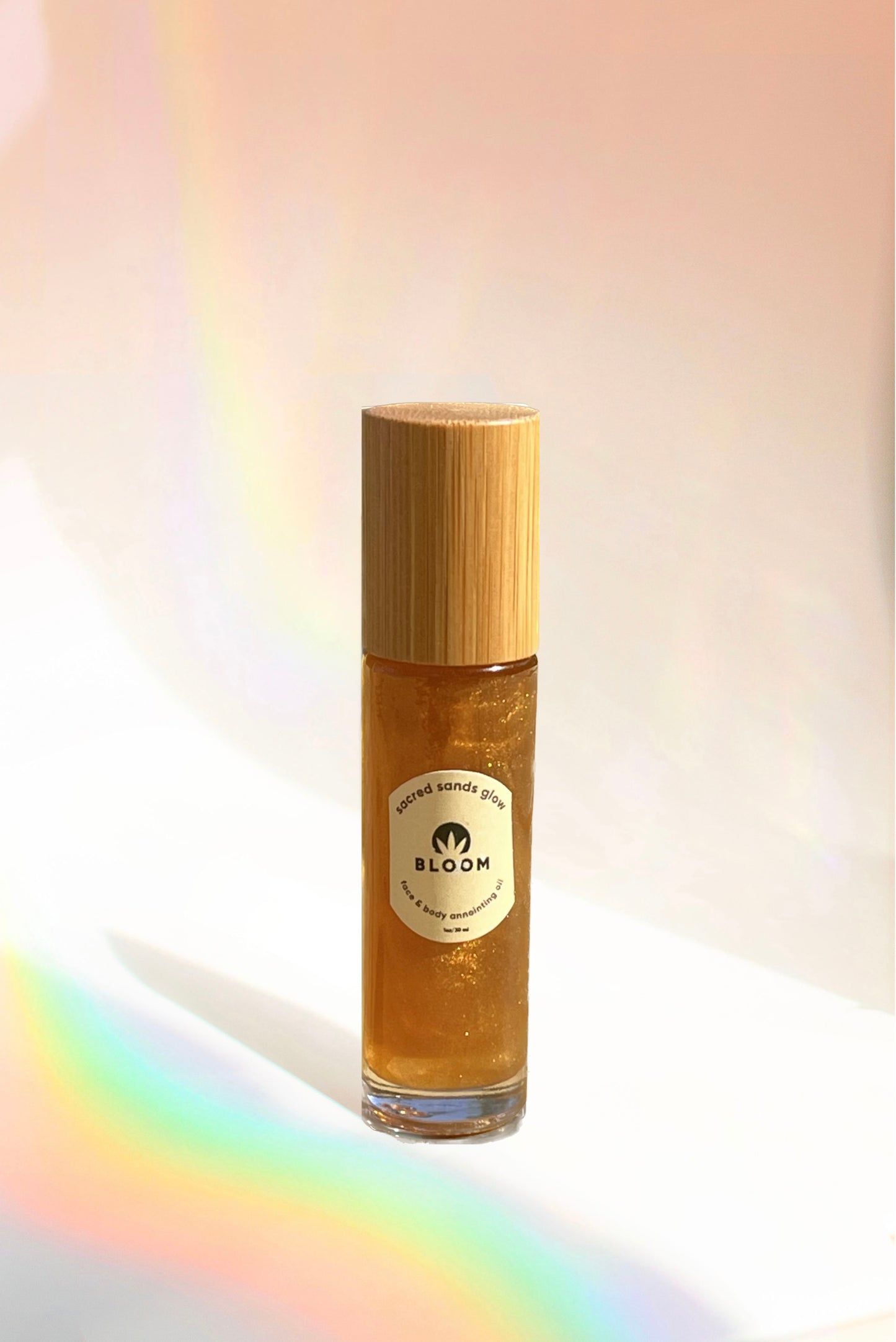 Sacred Sands Glow Oil in roller and 1 oz. dropper forms, featuring a nourishing blend of sea buckthorn oil, hemp extract, and citrus oils for a luminous, sun-kissed glow.
