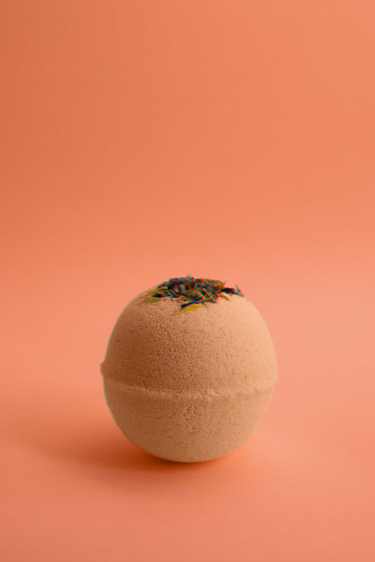 Flower Child Bath Bomb fizzing in water with dried flower petals and citrus aroma.
